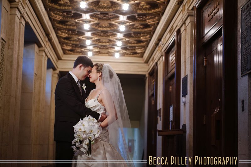 bride and groom under antique architectural lighting of Temple Israel in Minneapolis jewish wedding