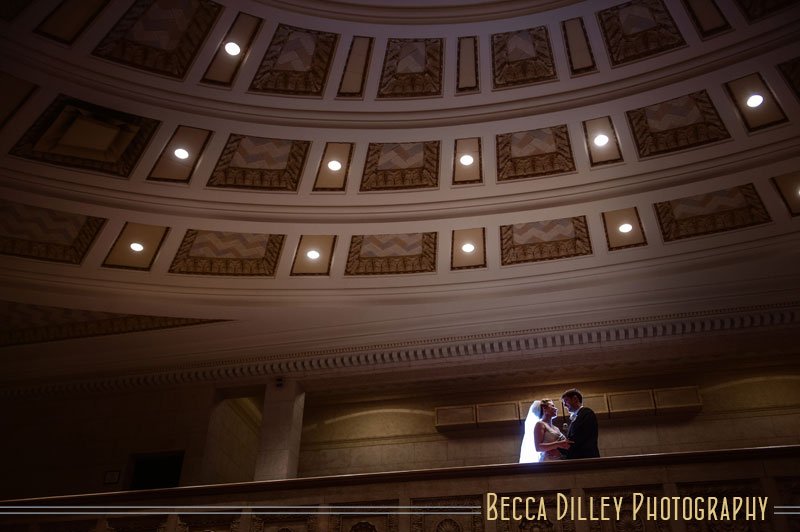 Bride and groom in silhouette on balcony of Temple Israel Minneapolis
