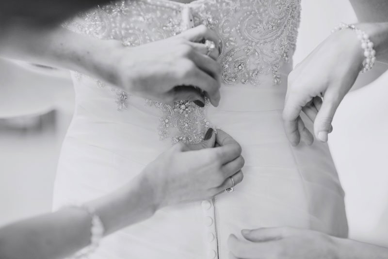 wedding dress with lace details being buttoned