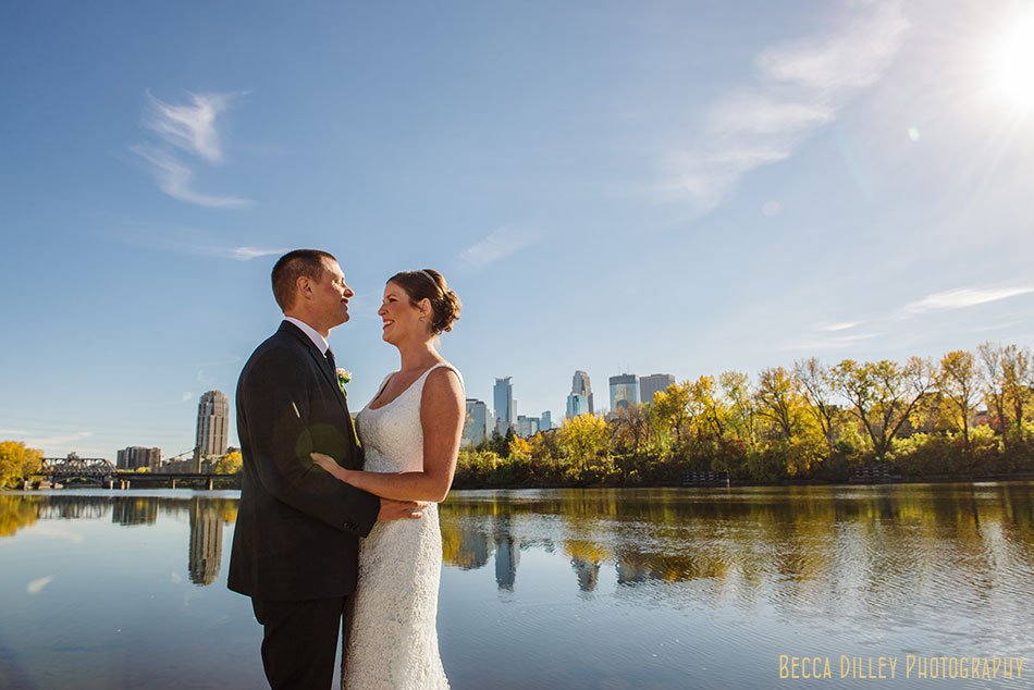 bride and groom on boom island with minneapolis skyline