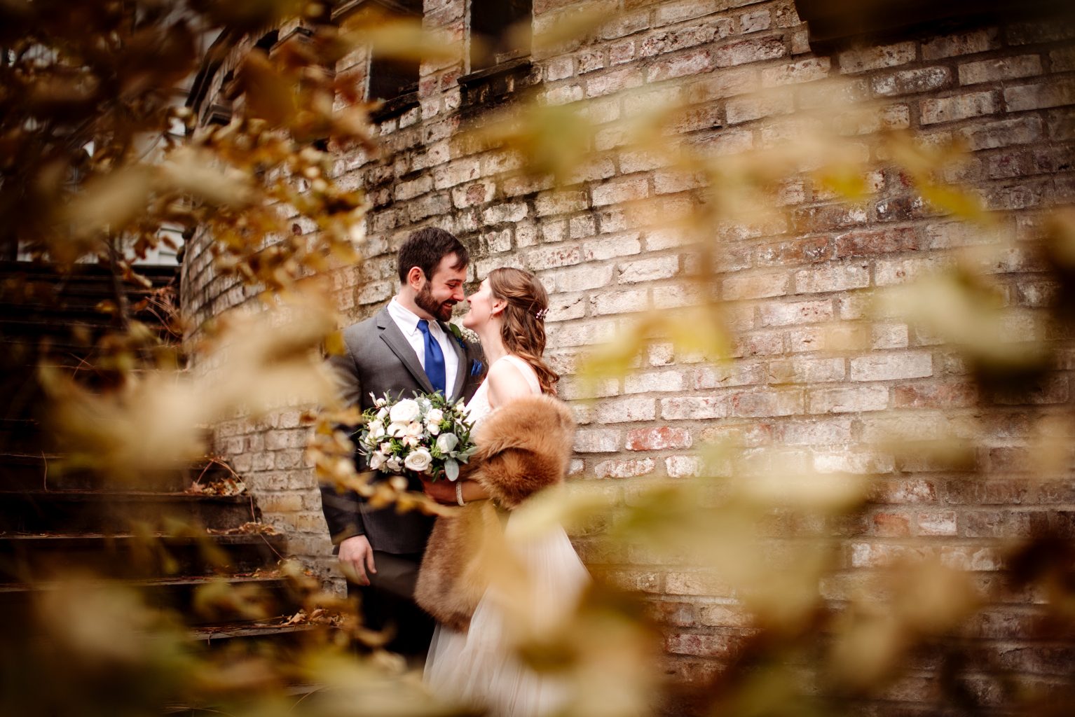 couple looking at each other framed by leaves for fall wedding at mn arboretum 