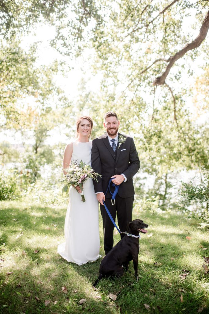 bride and groom and their dog in minneapolis park before wedding sunny summer day