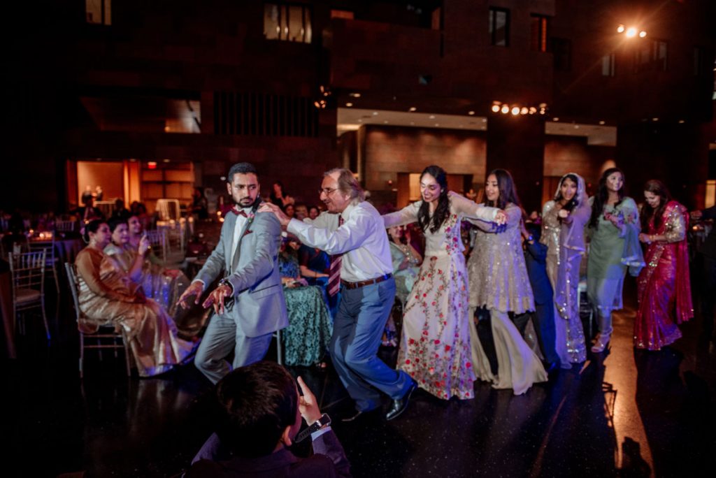 conga line forms during dancing at mulsim pakistani wedding at McNamara Center in Minneapolis